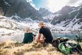 Father and son backpackers sit near the mountain lakeÃÆ encircle