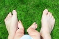 Father and son bare feet on green grass lawn at park. Parent with baby boy making first steps in life.Child exploring Royalty Free Stock Photo