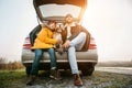 Father and son with beagle dog siting together in car trunk. Long auto journey break Royalty Free Stock Photo