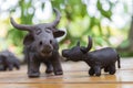 father and son buffalo clay sculpture on wooden background in outdoor