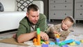 Father and son build tower using colorful wooden blocks Royalty Free Stock Photo