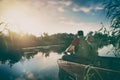 father and son catch fish from a boat at sunset