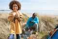 Father And Son Collecting Firewood On Beach