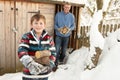 Father And Son Collecting Logs From Wooden Store