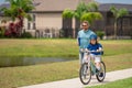 Father and son concept. Father teaching son riding bike. Father helping son to ride a bicycle in american neighborhood Royalty Free Stock Photo