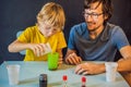 Father and son conduct chemical experiments at home. Home made slime