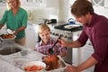 Father And Son Cooking Roast Turkey In Kitchen Together Royalty Free Stock Photo