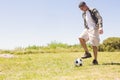 Mature adult male controlling classic black and white soccer ball on open grassy field, copy space Royalty Free Stock Photo