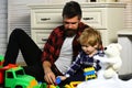 Father and son create toys from bricks. Dad and kid build of plastic blocks. Family daddy child leisure game. Loving dad Royalty Free Stock Photo