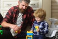 Father and son create toys from bricks. Father and son family time together at home. Dad and kid build of plastic blocks Royalty Free Stock Photo