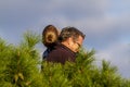 A father and son cuddling on top of a pine tree