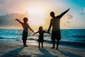 Father with son and daughter silhouettes play at sunset beach Royalty Free Stock Photo