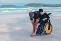 Father and son with disabilities at the beach