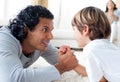 Father and son doing a arm-wrestling on the floor Royalty Free Stock Photo