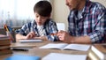 Father and son doing homework together, dad explaining task, school education Royalty Free Stock Photo