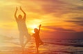 Father and son doing yoga at sunset sea Royalty Free Stock Photo