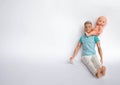 Father and son, dolls on a white background, father holds son in his arms, feeds his son. Caring for the family