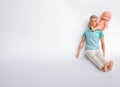 Father and son, dolls on a white background, father holds son in his arms, feeds his son. Caring for the family