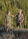 Father and son hunting and laughing in woods