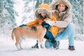 Father and son; dressed in Warm Hooded Casual Parka Jacket Outerwear walking with their beagle dog; they petting him and smiling Royalty Free Stock Photo