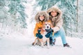 Father and son dressed in Warm Hooded Casual Parka Jacket Outerwear walking with their beagle dog in snowy forest cheerful Royalty Free Stock Photo