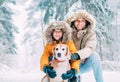 Father and son dressed in Warm Hooded Casual Parka Jacket Outerwear walking with their beagle dog in snowy forest cheerful Royalty Free Stock Photo