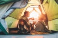 Father and son drink hot tea sitting together in camping tent Royalty Free Stock Photo