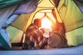 Father and son drink hot tea sitting together in camping tent. Traveling with kids and active people concept image Royalty Free Stock Photo