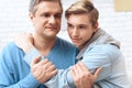 Son hugs beloved dad who holds his hand.