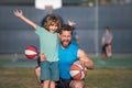 Father and son enjoying sport basketball outdoor. Childhood and parenting concept. Weekend sport man family concept.