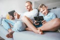 Father and son enthusiastically playing the electronic devices Royalty Free Stock Photo