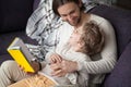 Father and son with fairytale book on couch