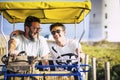 Father and son family together on a surrey bike have fun in outdoor leisure activity or summer holiday vacation - cheerful people