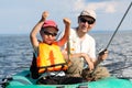 Father and son fish in a boat Royalty Free Stock Photo