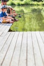 Father and son fishing in Lake while sitting on pier Royalty Free Stock Photo