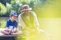 Father and son fishing in Lake while sitting on pier Royalty Free Stock Photo