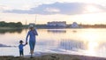 Father and son with fishing rods going along the river at sunset Royalty Free Stock Photo