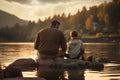 Father and son fishing together on a lake in the mountains at sunset, father and son sitting together on rocks fishing with rods, Royalty Free Stock Photo