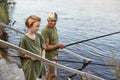 Father and son fishing on wooden stairs leading to water,, grandfather teaching his grandson to catching fish, family spending Royalty Free Stock Photo