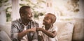 Father and son fist bumping while playing video game