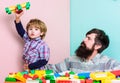 Father son game. Father and son create constructions. Bearded man and son play together. Every dad and son must do