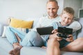 Father and son game players funs sit together at home on cozy so Royalty Free Stock Photo