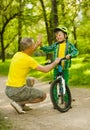 Father and son give high five while cycling in the park Royalty Free Stock Photo