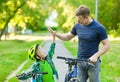 Father and son give high five while cycling in the park Royalty Free Stock Photo