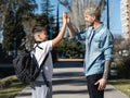 Father and son giving high five on the way to school on sunny day Royalty Free Stock Photo