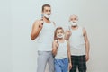 Father son and grandfather standing with shaving cream on their faces and holding razors