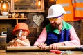 Father and son hammers nails with a hammer in a wooden board. Happy fatherhood.