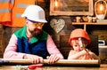 Father and son hammers nails with a hammer in a wooden board. Happy fatherhood.