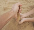 Father and son hands on sand. Close up Royalty Free Stock Photo