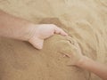 Father and son hands on sand. Close up Royalty Free Stock Photo